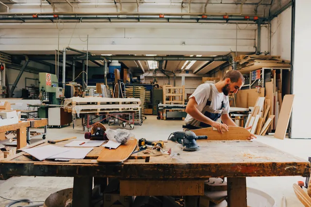 A joiner working at a bench in a timber workshop.