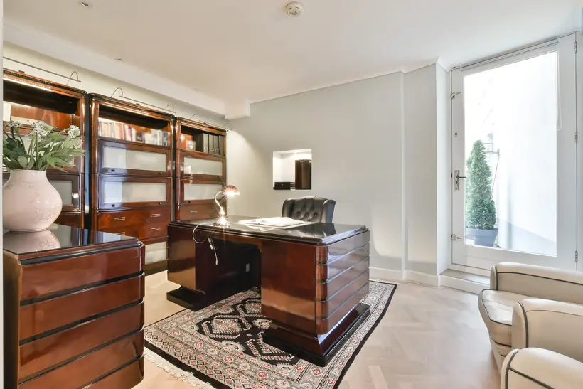 A working office with timber furniture and a desk set for a meeting.