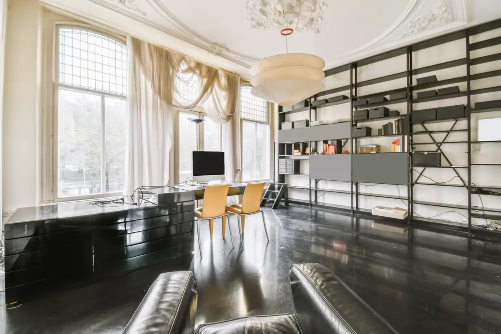 A study with a desk and full-height bookshelves.