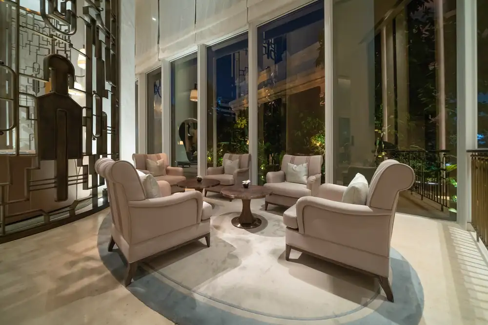 A softly lit sitting room with plush armchairs at night.