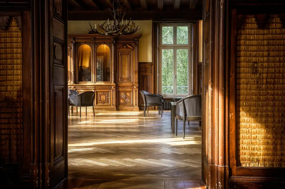 An enfilade of doorways opening through a panelled interior.