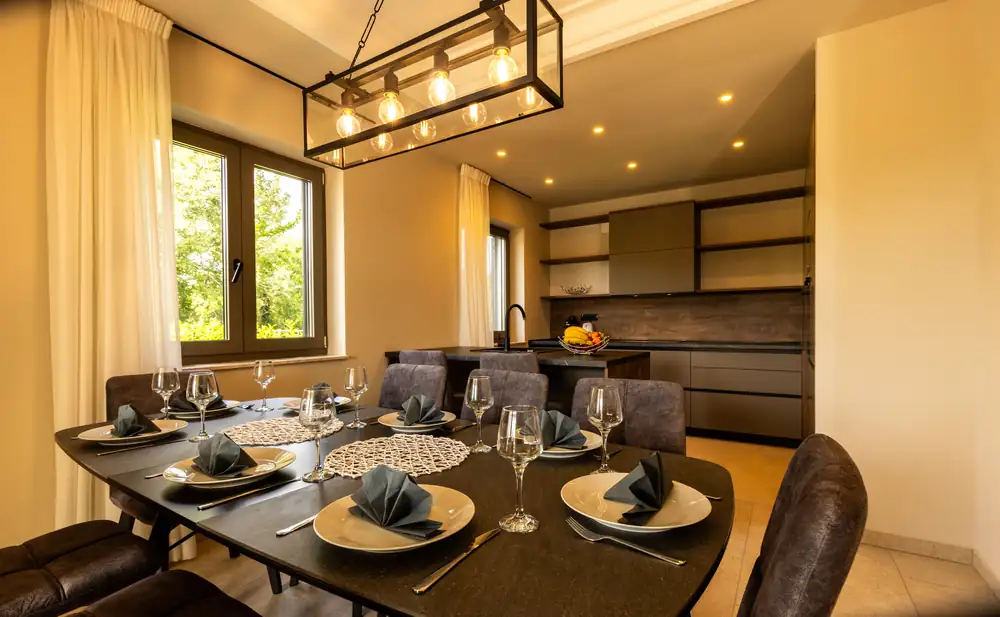 A dining table laid and ready in a bright room.