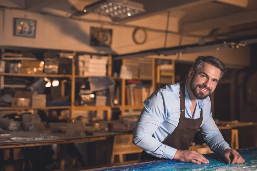 A craftsman setting mosaic tesserae by hand in his studio.